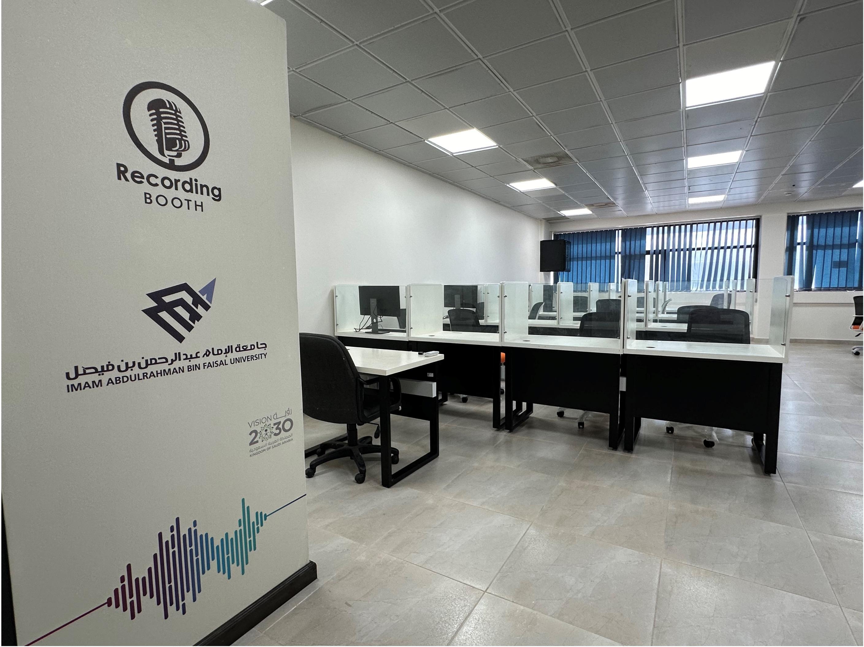 Chairs and tables with headphones in an audio recording room, for English Department.