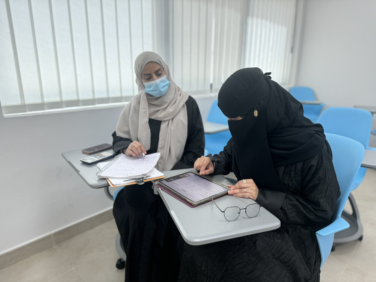 Female students in a classroom on interactive chairs, glass windows.